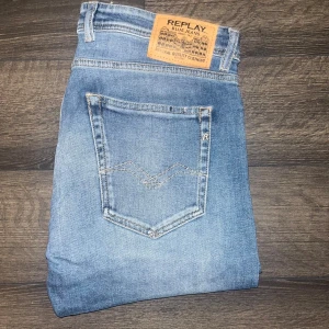 Replay jeans  - Snygga Replay Grover jeans i klassisk blå tvätt med lätt slitning. Modellen har raka ben, fem fickor och detaljerade sömmar på bakfickorna. Jeansen är tillverkade i bomull och har en normal passform som sitter skönt hela dagen. Midja 45cm, längd 102cm. JAG SKICKAR INGA FLER BILDER PÅ NÄR JAG BÄR JEANSEN :) 20 
