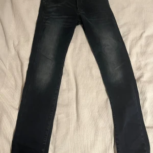 Jack & Jones Slim Glenn svarta jeans - Svarta jeans från Jack & Jones, modell Slim Glenn. Jeansen har en slim passform med klassisk femficksdesign och subtila slitningar på benen. Tillverkade i stretchigt denim för extra komfort och snygg siluett. Nyskick typ eftersom ja kanppy använt dom sen ja köpte. W30 L32.