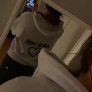 Grå hoodie ”New York” från Subdued  - Super snygg grå hoodie från Subdued i storlek XS med svart New York-tryck och hjärta på både framsidan och ryggen. Tröjan har huva med snörning och är jättebekväm då den är tillverkad i mjuk bomull. Intresse koll då den är helt slut såld och inte säljs längre! Perfekt nu för hösten!💕🍁