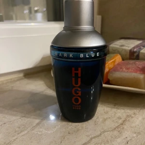 Hugo Boss Dark Blue - Eau de Toilette - Fräsch och maskulin doft med citrus, kryddor och träiga toner. Passar både vardag och fest. Parfymen passar året runt eftersom de har fräscha och lite mörkare dofter. Passar män och pojkar. Flaskan i mycket fint skick, ca 70 % kvar. Nypris ca 700 kr – säljes för 299kr.