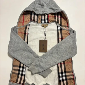 Grå burburry ziphoodie  - Säljer en klassisk grå burburry ziphoodie i storleken M (har även i svart - under min profil). Den har dragkedja och burburry märket broderat på brösten. Skickas inom 24 timmar!