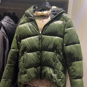 Save the duck jacka  - Mörkgrön dunjacka med glans från save the duck, jackan är i storlek xl men sitter mer som L. Jackan är använd en vinter och är väldigt sparsamt använd. Skriv vid frågor eller funderingar! Priset kan sänkas vid snabb affär!