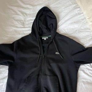 Svart hoodie från Lacoste med dragkedja - Ny skick knappt använd säljer eftersom den är för liten 