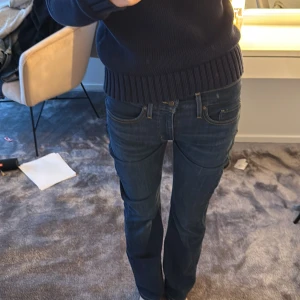 Levi's 505 mörkblå jeans bootcut - Säljer ett par klassiska Levi's 505 jeans i mörkblå tvätt med bootcut passform. Jeansen har guldfärgade sömmar och mellanhög midja. Materialet är slitstarkt denim och de har den ikoniska Levi's-loggan på bakfickan.