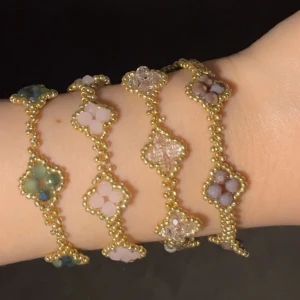 Färgglada pärlarmband med blommor - Fyra handgjorda armband med små guldfärgade pärlor och blommor i olika färger: grönt, rosa, lila och transparent. Varje armband har ett unikt blommönster av glaspärlor som ger en söt och trendig look. Perfekt för att addera färg och stil till din outfit. 30 kr/st 