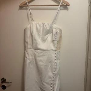 Miniklänning - Vit miniklänning, storlek M, helt ny! Slutar ungefär mitt på låret