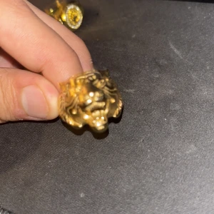 Guldfärgad ring med tigerhuvud - Cool statementring i guldfärg med ett detaljerat tigerhuvud framtill. Ringen har en bred design och glänsande finish som verkligen drar blickarna till sig. Perfekt för dig som vill sticka ut med ett djuriskt smycke.