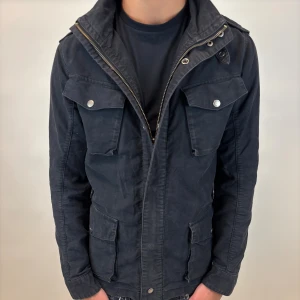 Woolrich Jacka - Hej! Säljer nu denna väldigt snygga och eftertraktade Woolrich Fieldjacka!  Jackan är slutsåld överallt och går inte att få tag på… jackan är perfekt nu till hösten/vintern  Storlek L fits M Skick 9,5/10  Ny pris: 6000 kr Säljs för: 1299 kr