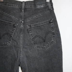 Levi's svarta high waisted jeans - Snygga svarta jeans från Levi's med hög midja och tapered ben. Klassisk femficksmodell med Levi's patch bak och cool faded tvätt. Jeansen har knapp och dragkedja framtill, och är gjorda i slitstarkt denim. Använda ett fåtal gånger. True to size. 