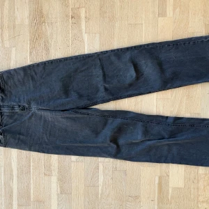 Svarta jeans från Lindex, raka ben - Svarta jeans från Lindex med raka ben och klassisk femficksdesign. Jeansen har en enkel knapp med 'Detroit Denim' . Hör av er om ni inte tycker priset passar eller vill ha mått