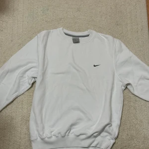 Vit sweatshirt från Nike - gammal kollektion😍 - Vit sweatshirt från Nike från en gammal kollektion - tidiga 20-talet. Tröjan har rund hals, långa ärmar och ribbade muddar vid ärmslut och nederkant. Perfekt för en clean och sportig look. Säljs ej längre! 😍