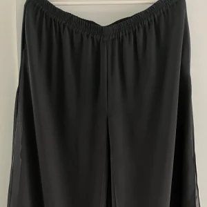 Kjol med byxor - Säljer denna kjol som har inbyggda vida byxor i mesh. Lite genomskinliga men går att ha på sig utan att det syns igenom. Använda men i bra skick.