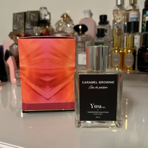 Caramel Brownie Eau de Parfum - Trendig parfym i samarbete med Theodoros Kalotinis. Flaskan rymmer 50 ml och har en snygg, modern design. Perfekt för dig som vill sticka ut med något unikt och lekfullt.