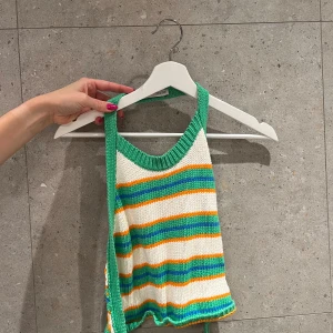 Randig stickad linnetopp från Zara - Säljer en färgglad stickad linnetopp från Zara i storlek M. Toppen har gröna, vita, orangea och blå ränder, gröna kanter och knytband i sidan. Den passar super på mig som är en S också!! 
