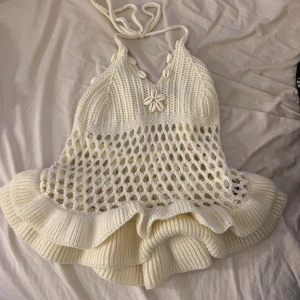Stickad knyt topp - Säljer en jätte söt somrig/festlig topp som man knyter runt halsen, även fina snäckor som detalj, knappt använd 🥰