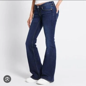 Mörkblå bootcut jeans 152 - Snygga mörkblå jeans i bootcut-modell med klassiska fem fickor och orangea sömmar. Jeansen har låg midja och är tillverkade i ett mjukt denimtyg som ger en skön passform. Perfekta för dig som gillar en retrostil med utsvängda ben. Bell jeans ❣️