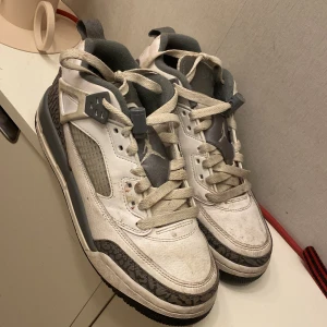 Nike Air Jordan 3 Retro grå/vit - Säljer ett par Nike Air Jordan 3 Retro sneakers i vitt och grått med ikoniskt elephant print runt hälen och tån. Skorna har snörning, rund tå och platt sula. Ovandelen är i skinn och detaljer i syntet. Perfekta för dig som gillar klassiska och sportiga sneakers.