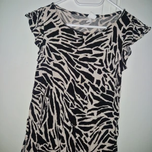 Zebra tshirt - Snygg tshirt med svart och beige zebramönster. Perfekt för dig som vill sticka ut med ett djurmönster och en cool vibe.