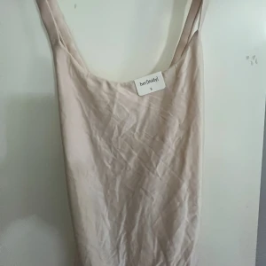 Beige linnetopp från Bik Bok - Säljer en beige linnetopp från Bik Bok med breda axelband och justerbara spännen baktill. Toppen har en enkel och stilren design med mjuk, slät yta och är perfekt för en clean look. Passar dig som gillar minimalistiska plagg.