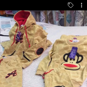 Beige hoodie med röd luva och apa från 1år till 3år  - Cool beige hoodie med röda detaljer och stor röd luva. Framsidan har ett broderat A och svarta detaljer på ärmen. Matchande tröja med Paul Frank-apa framtill. Perfekt för dig som gillar lekfull stil och streetwear-vibe. Från 1år till 3år 