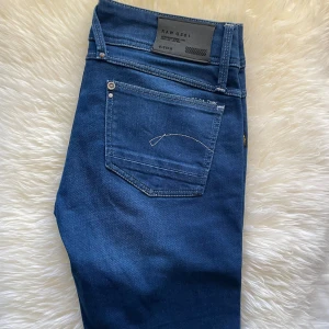  G-Star RAW lågmidjade jeans - Snygga lågmidjade blå jeans från G-Star RAW med klassisk femficksdesign och tydliga logodetaljer. Jeansen har smal passform och är tillverkade i stretchig denim för extra komfort🌸 Nypris ligger på ungefär 1500kr till 2000kr beroende på varifrån man köper dom från💗W30 & L32✨