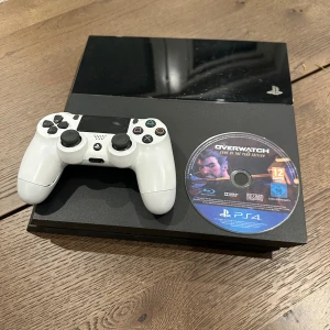 PlayStation 4 Med Spel - PlayStation 4 konsol med en handkontroller.   Det som följer med:  PS4 konsol 1st handkontroller  Strömkabel Hdmi kabel Det följer dessutom med ett spel 1. OVERWATCH  Konsolen och kontrollen är väldigt god skick.   Lagringsutrymme: 500GB  CD spelaren är testad och fungerar som den ska   Har en till handkontroll ifall man vill ha det också men då gäller det att kontakta mig.  Har ni frågor hör gärna av er!