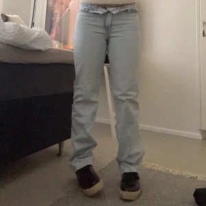 Ljusblå raka jeans - Säljer ett par ljusblå jeans med rak passform och klassiska fem fickor. Jeansen har normal midja och är tillverkade i denim med en snygg, enkel look. Perfekta för dig som gillar en clean och avslappnad stil.
