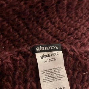 Vinröd stickad snood från Gina Tricot - Mysig vinröd snood-halsduk från Gina Tricot i grovstickad design. Halsduken är rund och enkel att slänga över huvudet för en avslappnad look. Materialet består av 50% akryl och 50% polyester, vilket gör den både varm och lätt att bära.