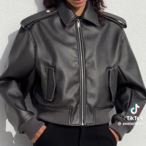 Svart skinnjacka Axel Arigato - Säljer en svart vegansk skinnjacka från Axel Arigato med oversized passform, markerade axlar och bred krage. Jackan har dragkedja framtill, ribbade muddar och coola detaljer vid axlarna.