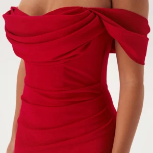 Röd offshoulder långklänning - Snygg röd långklänning med offshoulder och draperad överdel. Perfekt för dig som har bal nästa år! OBS det hänger lite lösa trådar (därav priset) men det är något som går att lösa!                       Nypris; 1999 