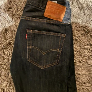 Levi's 501 jeans mörkblå W32 L32 - Klassiska Levi's 501 jeans i mörkblå färg med snygga kontrastsömmar och ikonisk läderpatch bak. Modellen har rak passform & tillverkad i slitstarkt bomullsdenim. Perfekt för dig som gillar tidlös stil och vill ha ett par jeans som alltid funkar. Billigt! Fynda!
