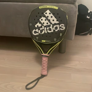 Essnova Carbon 2.0 - Adidas Essnova Carbon 2.0 padelracket med head heavy balans och soft kärna. Racketet har tydliga tecken på slitage och repor längs ramen, men det märker man inte av som en vanlig spelare, bara proffsen som gör! Det är  fortfarande helt spelbart. Perfekt för dig som vill ha ett kraftfullt racket till ett bra pris.