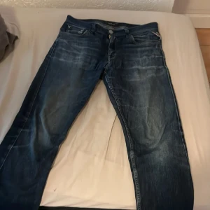 Blå jeans från Replay passar dig som är 158-168cm lång  - Säljer jeansen pga att det jag haft de länge nu och de passar inte bra längre på mig, men det är ett par snygga blå jeans från Replay med klassisk femficksdesign och coola slitningar. Jeansen har raka ben och tydliga kontrastsömmar, samt Replay-logga på bakfickan och i linningen. Perfekta för dig som gillar en tidlös och avslappnad stil.