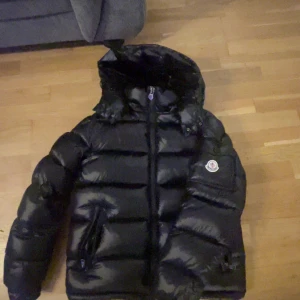 Moncler maya svart - En Skön jacka nu som passar till höst/vinter/vår den är väldigt bekväm att ha på sig nu till vintern jackan är i storlek 2=S kommer med moncler påse och prislapp jackan är i ny skick knappt använd,Skriv om intresse så kan vi diskutera om priset