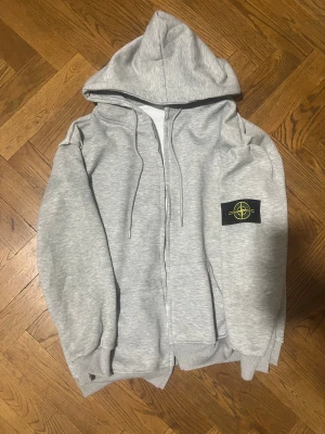 Grå hoodie från Stone Island - Jätte fin tröja som är nästan ny använd bara få gånger den har inga skador eller liknande skriv för mer information gärna 