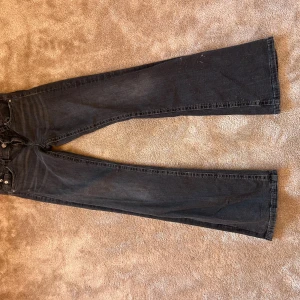 Mörkgrå bootcut jeans med fickor - Snygga mörkgrå jeans med bootcut passform och klassiska fickor både fram och bak. Jeansen har en rak siluett med lätt utsvängda ben och är tillverkade i jeansmaterial. Perfekta för dig som gillar en avslappnad stil med lite edge.