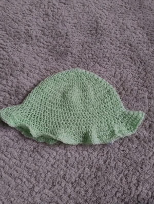 Handgjord virkad ljusgrön buckethat - Söt virkad buckethat ljusgrönt garn med bred volangkant runt hela hatten. Perfekt för dig som vill sticka ut med en unik accessoar. Hatten har en mjuk och luftig känsla, passar skönt på huvudet och ger en chill vibe till din outfit. Jag har virkat den själv om någon undrar 🙃🤗
