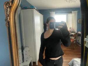 Svart stickad oneshoulder tröja - Säljer en svart stickad tröja med oneshoulder-design och lång ärm. Tröjan har en cool asymmetrisk halsringning och är lite loose i passformen. Perfekt för dig som gillar att sticka ut med din stil och vill ha något mjukt och bekvämt.