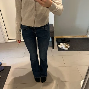Lågmidjade jeans - Säljer dessa mörkblåa flare jeans i modellen Freja, köpta på barnavdelningen på Lindex. Medelhöga i midjan men skulle säga att de är mer mot det lågmidjade hållet. Passar mig perfekt som vanligtvis har storlek xs, 32.  Skick 10/10  Nypris: 399kr 