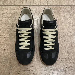 Maison Margiela gats. - Maison Margiela skor i svart skinn och mocka. Skorna är i väldigt bra skick.     Storlek 40.    Box o dustbag medföljer vid köp.