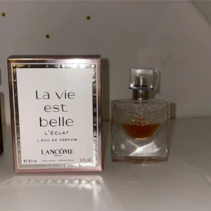 La Vie Est Belle L'Éclat Lancome parfym - Fräsch och modern parfym från Lancôme. Innehåller noter av apelsinblomma, vita blommor, iris, jasmin sambac, vanilj, sandelträ och patchouli. Volym: 30 ml återstrående mängd på bild kvar!!!!. Perfekt för dig som vill sticka ut med en unik doft. Mycket hållbar. 