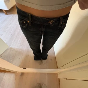 Blåa Miss Me jeans med broderi - Säljer ett par blåa jeans från Miss Me med snygga detaljer som broderad logga och dekorativa knappar. Jeansen har låg midja, raka ben och klassisk femficksdesign. Materialet är slitstarkt denim med kontrastsömmar och cool tvättad look.