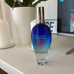Escada Santorini Sunrise parfym - Fräsch parfym från Escada med snygg blå flaska och modern design. Parfymen är användt men finns mycket kvar. 100ml