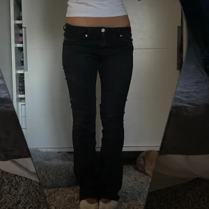 Svarta lowwaist bootcut jeans - Säljer ett par svarta bootcut jeans från monki. De är både snygga och sköna, perfekta nu till hösten. De är i storlek W25