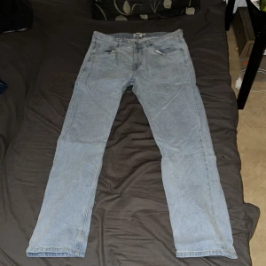 Ljusblå slim jeans från 157, W36 L32 - Slim fit jeans i ljusblå tvätt från 157, med klassisk femficksdesign och raka ben. Jeansen har snygga kontrastsömmar och en enkel look som passar till sneakers eller boots. Perfekt för dig som gillar en clean och avslappnad stil.