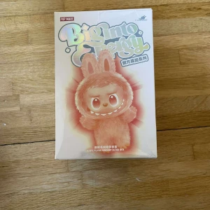 Pop Mart Big Into Energy Vinyl Plush Pendant Blind Box - Pop Mart Big Into Energy vinyl plush pendant blind box, oöppnad och i nyskick. Perfekt för samlare eller som present! Originalförpackning och innerpåse är obrutna. Inga synliga skador på förpackningen förutom lätt hörnslitage.