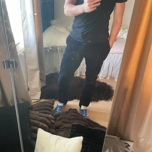 Svarta manchesterbyxor These Glory Days - Säljer ett par svarta manchesterbyxor från These Glory Days i storlek 50. Byxorna har klassisk rak passform, tydlig manchesterstruktur och stängs med dragkedja och knapp. Perfekta för dig som gillar stilrena och bekväma byxor med lite retrovibe.