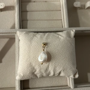 Pearl charm från Muli collection - Säljer pearl charm från Muli collection. Hänget har en minimalistisk design och passar perfekt till en tunn kedja. Perfekt accessoar för att ge din look en lyxig touch. Ordinarie 299kr, pris 199kr
