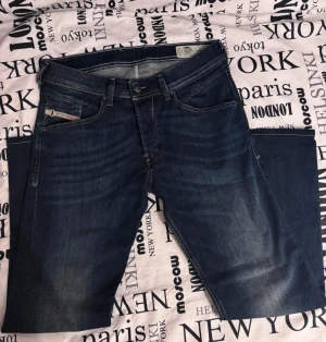 Mörkblå jeans straight fit - Snygga mörkblå jeans med klassisk femficksdesign och raka ben. Jeansen har diskreta slitningar framtill och bakfickor med Replay-logga. Perfekt passform och stilren look, tillverkade i mjukt denimtyg.