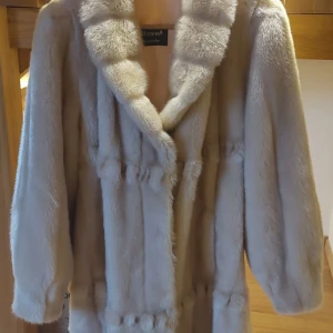 Beige pälsjacka från Modena - Säljer en superfin beige, syntetisk pälsjacka från Modena. Den är långärmad och perfekt för vintern. Jackan har en lyxig känsla med sitt mjuka material och stilrena design. Passar perfekt för både vardag och festliga tillfällen. Håll dig varm och snygg i vinter! 🧥❄️